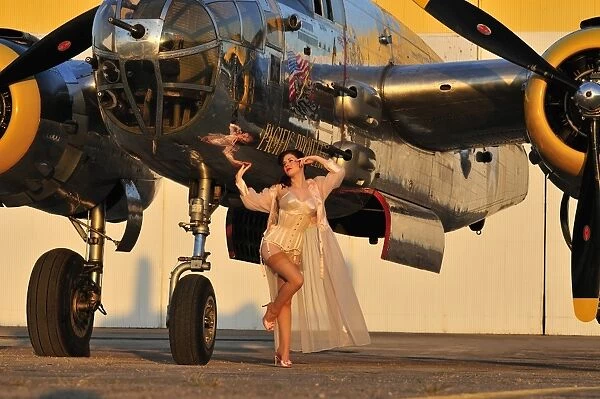 Sexy 1940s pin-up girl in lingerie posing with a B-25 bomber