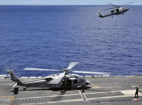 SH-60 Sea Hawk helicopters land aboard the aircraft carrier USS Ronald Reagan