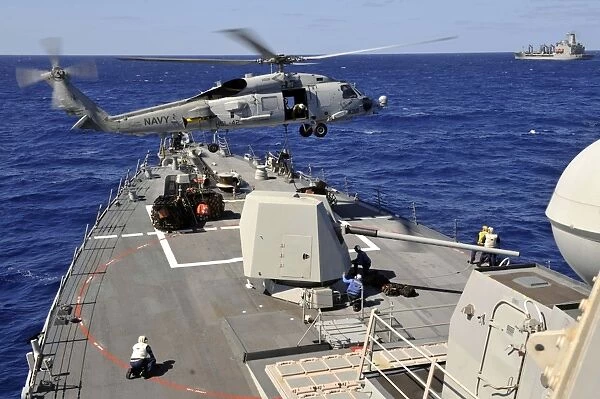 An SH-60B Sea Hawk helicopter picks up a pallet from USS Jason Dunham