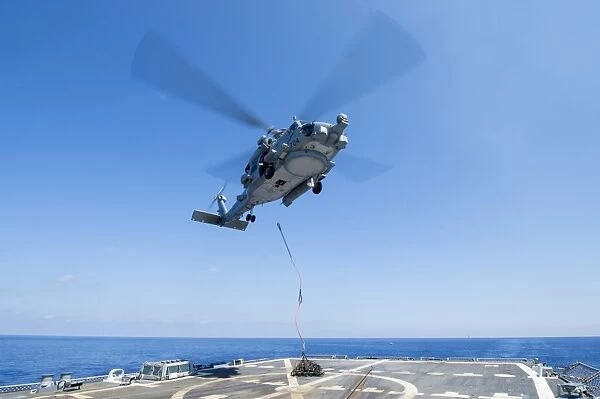 An SH-60R Seahawk delivers supplies during a vertical replenishment
