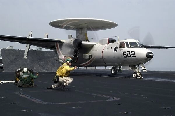 A shooter gives the signal to launch an E-2C Hawkeye