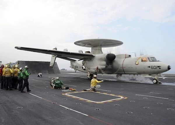 A shooter signals the launch of an E-2C Hawkeye aboard USS Abraham Lincoln