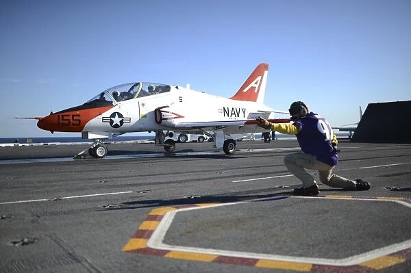 Shooter signals to the pilot of a T-45C Goshawk training aircraft