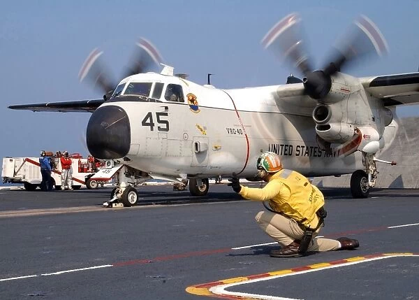 Signalman gives the launch signal to a C-2A Greyhound