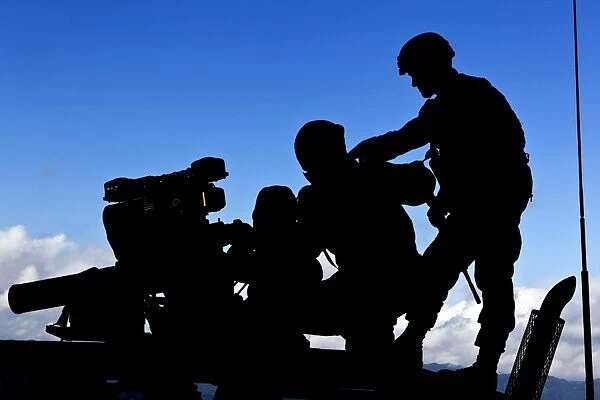 Silhouette of soldiers operating a BGM-71 TOW guided missile system