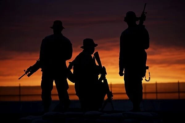 Silhouette of U.s Marines on a bunker at sunset in Afghanistan