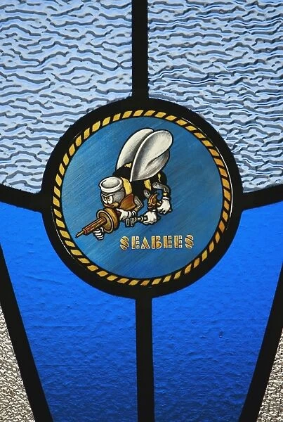 A single Seabee logo built into a stained-glass window