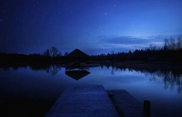 A small pier in a lake against starry sky, Moscow region, Russia