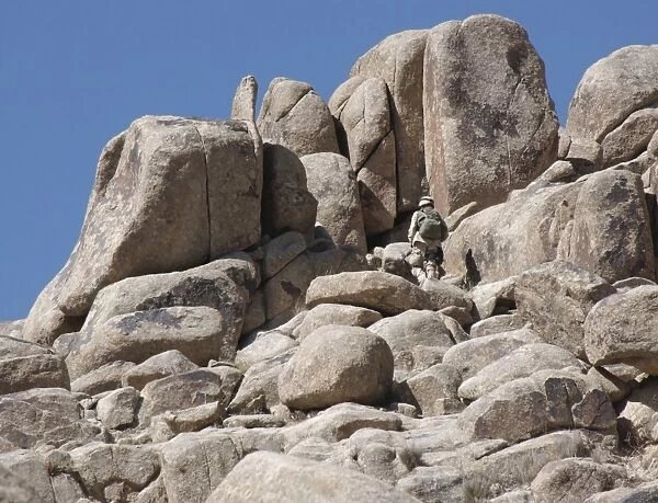 A soldier climbs a mountain
