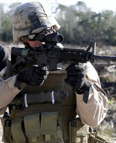A soldier looks through the scope of a M-4 carbine