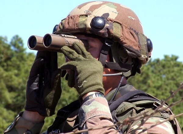A soldier scans an area for enemy forces