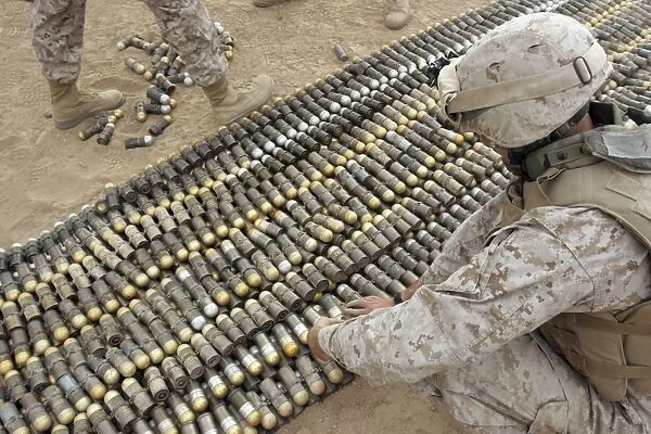 Soldiers arrange all the ordnance confiscated from caches into one big pile to be