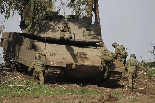 Soldiers climb into an Israel Defense Force Merkava Mark IV battle tank