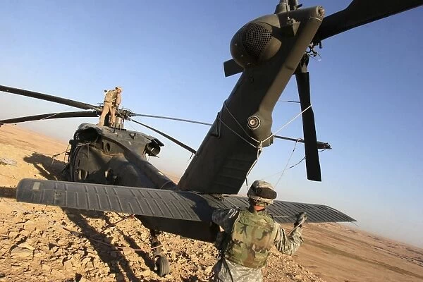 Soldiers prepare a UH-60 Black Hawk helicopter for transport