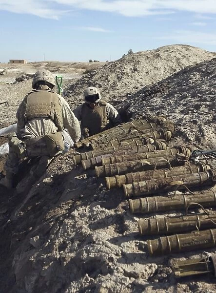Soldiers unearth 82mm Chinese mortars from a weapons cache