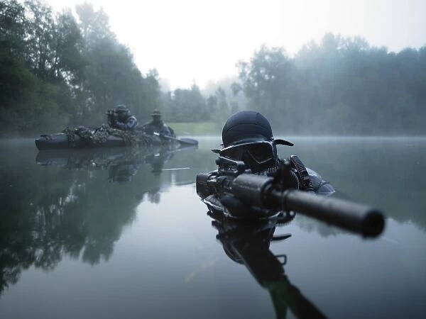 Special operations forces combat diver transits the water armed with an assault rifle