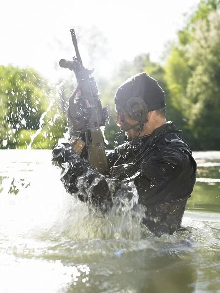 Special operations forces soldier emerges from water armed with a Steyr AUG assault rifle