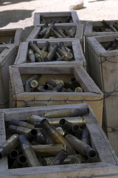 Spent. 50-caliber machine gun shell casings sit inside wooden boxes