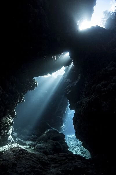Sunlight descends underwater and into a crevice in a reef in the Solomon Islands
