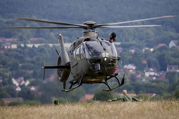 A Swiss Air Force EC-635 helicopter landing in a field