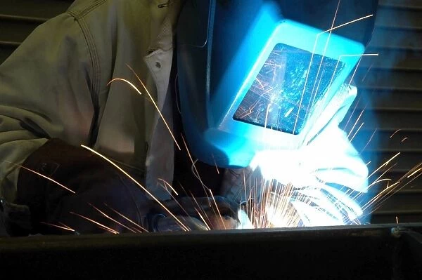 A technician welds metal together