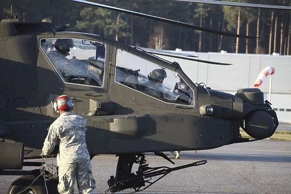 U. S. Army AH-64D Apache helicopter pilots conduct preflight checks