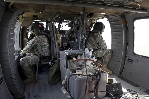 U. S. Army soldiers watch for hazards during a flight to provide air support