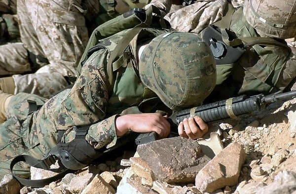 U. S. Marine Corps Private takes cover, protecting his 5. 56 mm M16A2 rifle