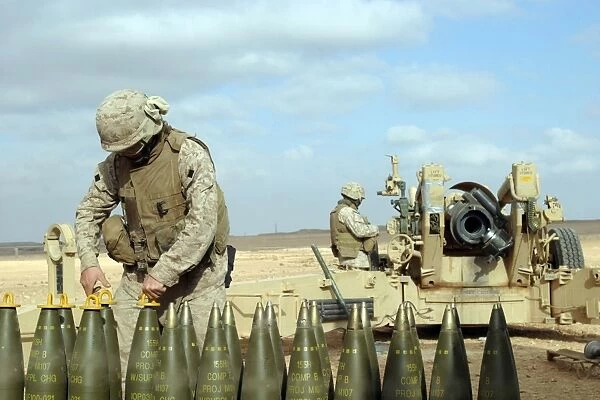A U. S. Marine prepares howitzer rounds to be fired near Baghdad, Iraq
