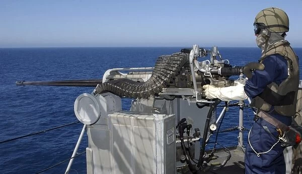 A U. S. Navy Gunners Mate firing a. 50-caliber machine gun during weapons training