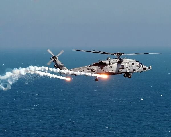 A U. S. Navy HH-60H Seahawk Helicopter dispenses flares and chaff