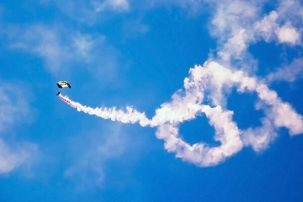 A U. S. Navy Parachute Team Leap Frogs crewmember descends through the sky