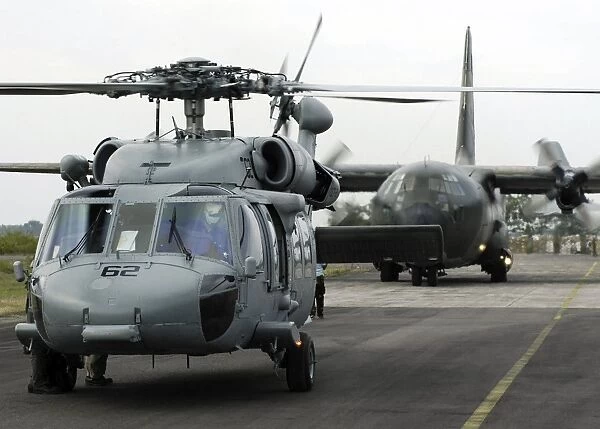 U. S. Navy SH-60B Seahawk helicopter and an Australian C-130 Hercules prepare for takeoff