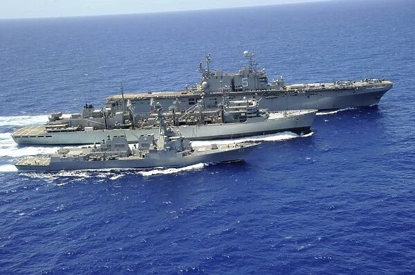 USS Peleliu and USS Spruance conduct a replenishment at sea with USNS Rainier