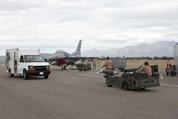 Weapons loaders prepare to load a GBU-38 JDAM on an F-16