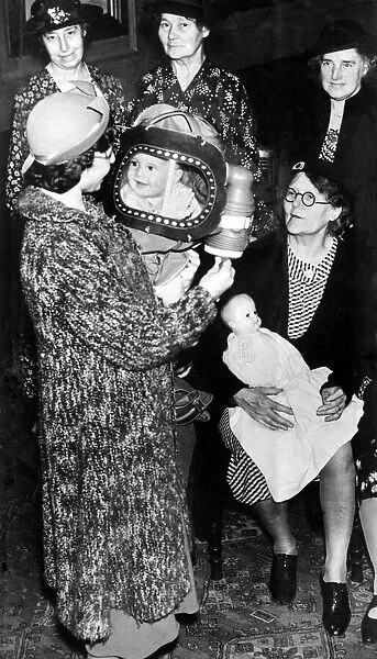 A baby in a gas mask smiles at her mother. 25th August 1939
