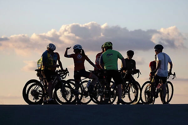 Group of cyclists silhouetted at sunset