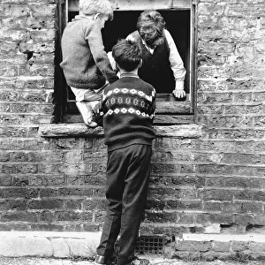Boys at a boarded up window, Balham, SW London