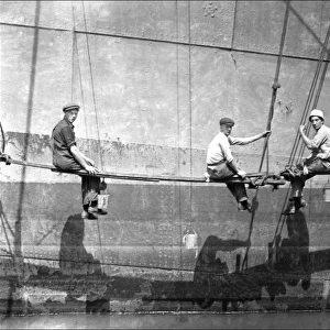 Men painting the side of a large boat