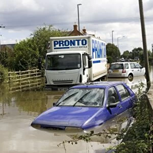 Flooding - cars and lorries partly submerged on flooded road into Newtown, Tewkesbury, Gloucestershire, UK following unprecedented flooding of Rivons Avon and Severn above 1947 level