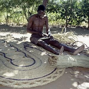 A man makes attractive floor mats from dried palm fronds near Liwonde