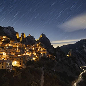 Star trail in the night sky over the old village of Castelmezzano, Dolomiti Lucane