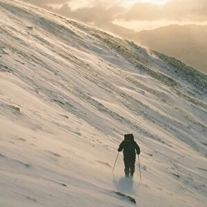 A mountaineer on Seat Sandal in the Lake District UK in winter weather