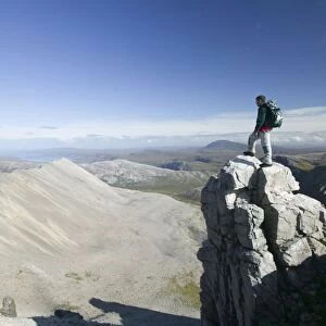 A walker on the peak of Foinaven in Sutherland Scotland UK