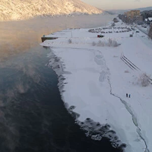 An aerial view shows people walking on the bank of the Yenisei River in Divnogorsk