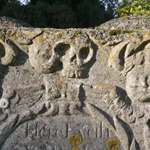 Skull carved on headstone in church graveyard, St. Andrew's Church, Wickham Skeith, Suffolk, England, october
