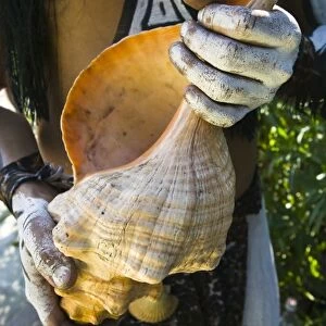 Mexico, Guerrero, Zihuatanejo. Young Man in Mayan Costume (MR) holding large Conch Shell
