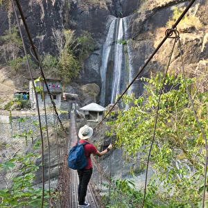 Tourist walking on suspending bridge with waterfall, Baguio, Benguet Province, Philippines