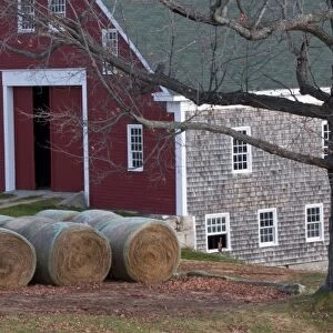 USA, Maine, New Gloucester. Hay bales sitting outside a barn at Shaker Village