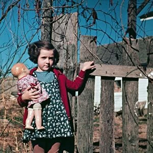 GIRL WITH DOLL, c1941. Portrait of a girl holding a doll. Photograph, c1941